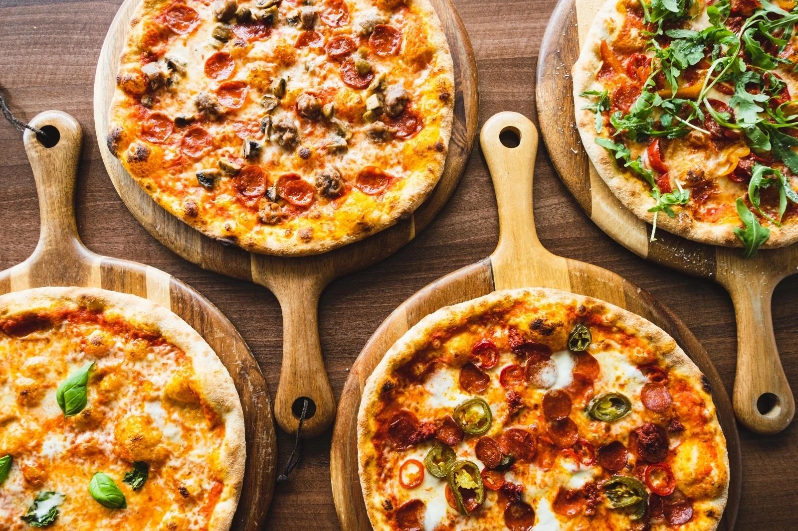 Four pizzas on wooden boards